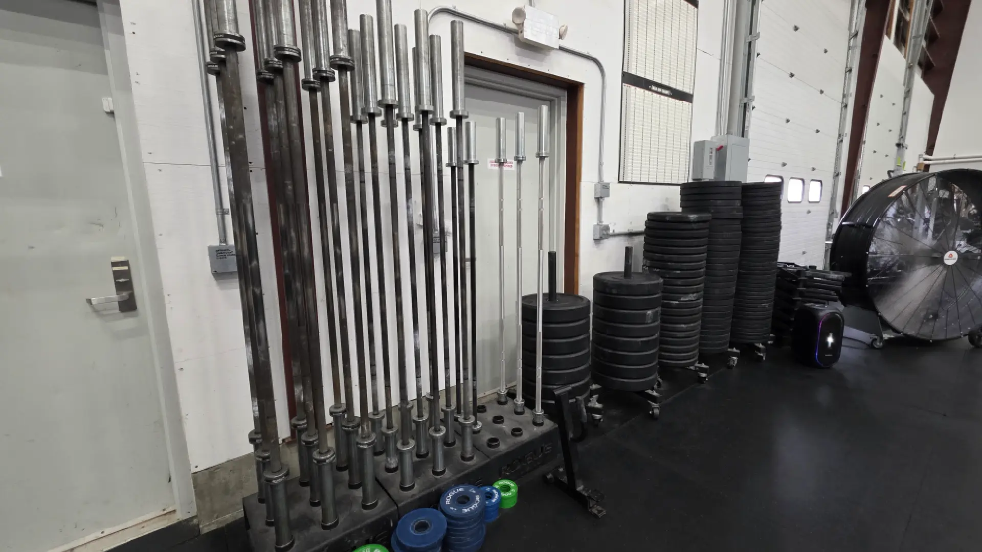 Barbell rack with olympic bars and stacked plates at O.N. Athletics in Groton, CT