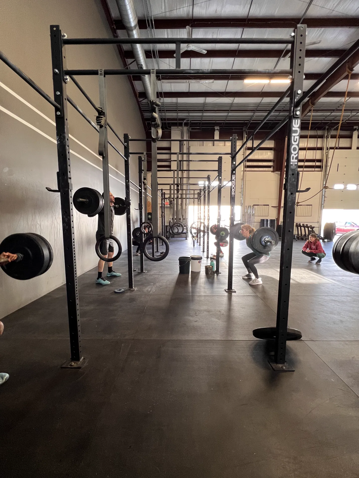 Coach watching an athlete lift under the rig during a CrossFit Dýr class in Mystic, CT